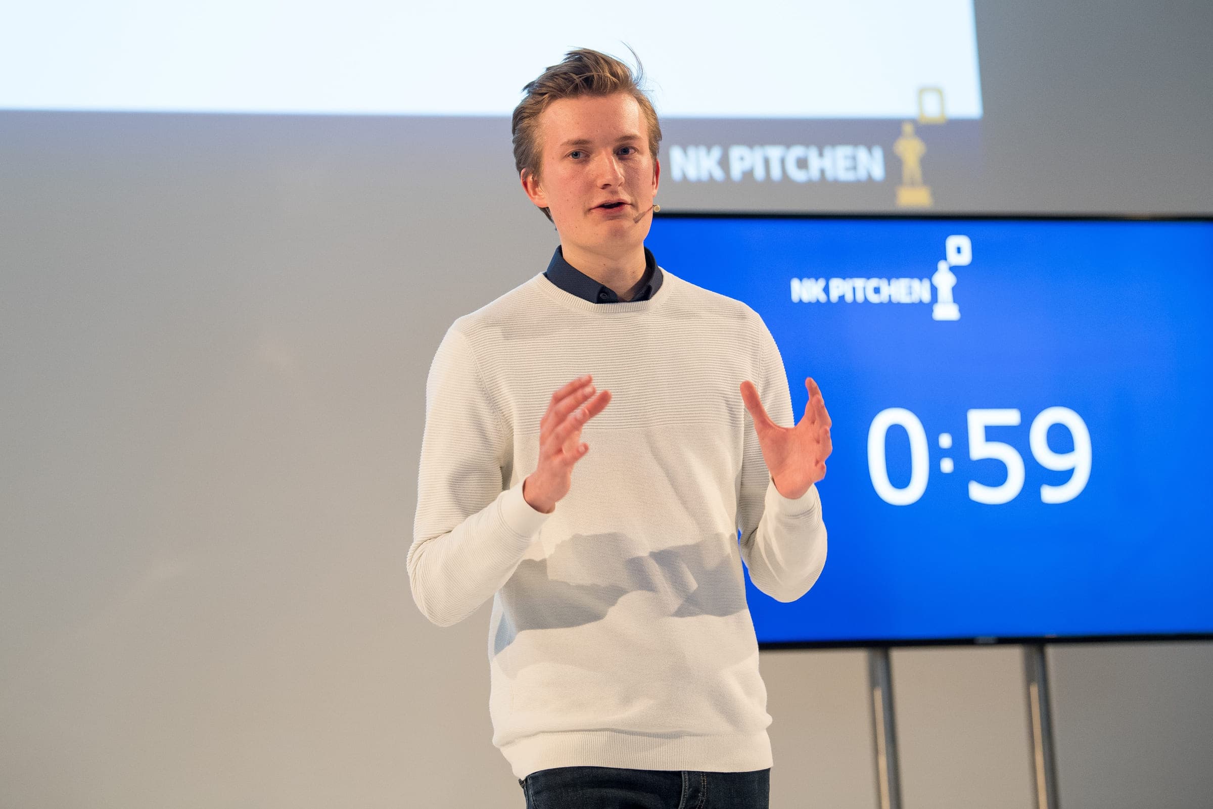 Ondernemer pitcht zijn bedrijf op het podium tijdens het NK Pitchen