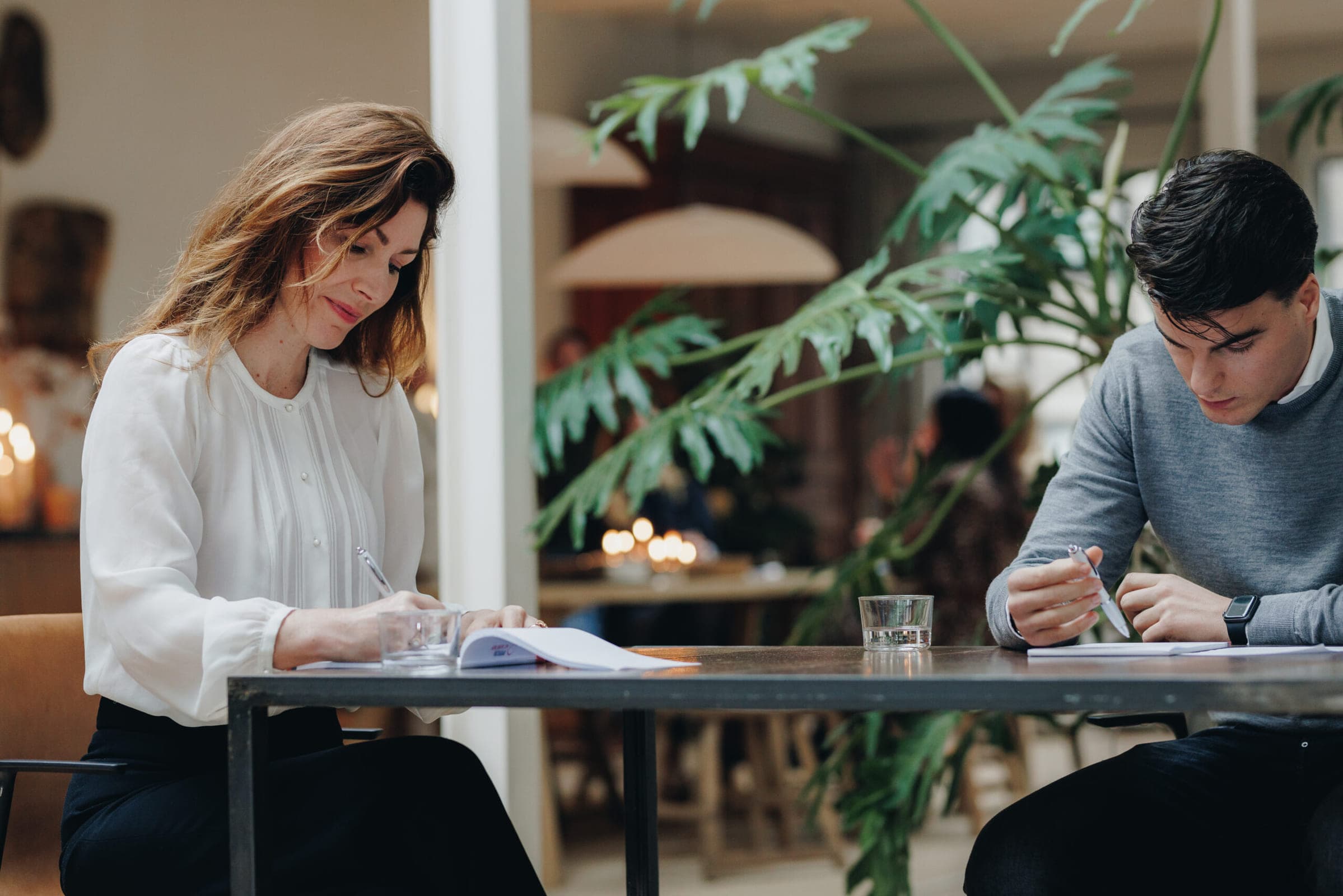 Twee deelnemers werken aan tafel aan hun pitch