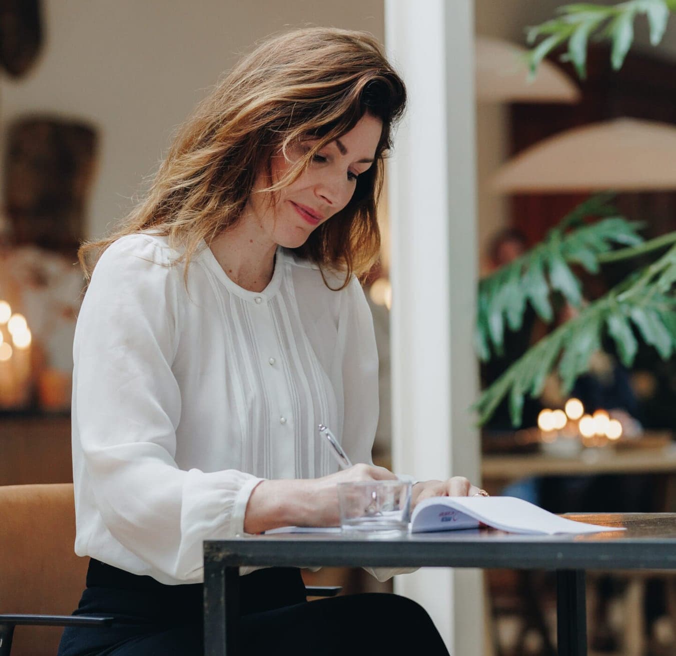 Deelnemer schrijft aan tafel de opbouw van haar pitch uit