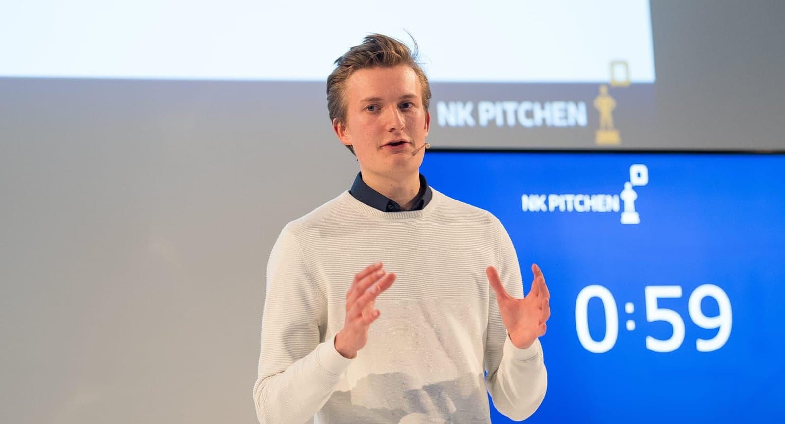 Deelnemer pitcht op het podium van het NK Pitchen