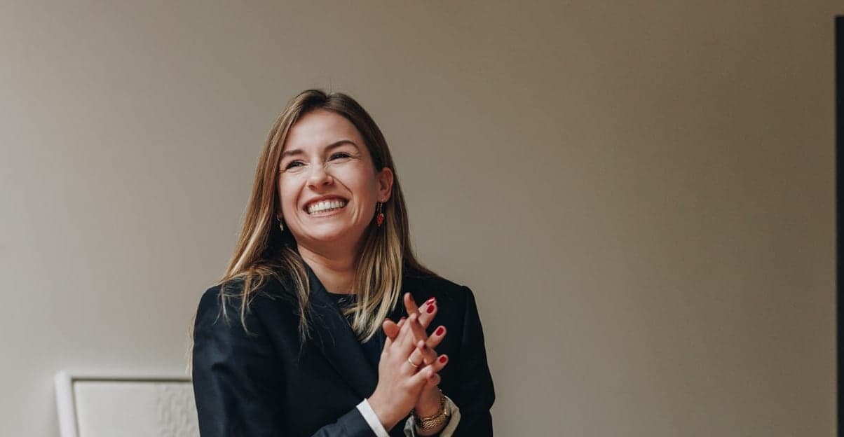 Deelnemer staat lachend voor de groep na haar pitch