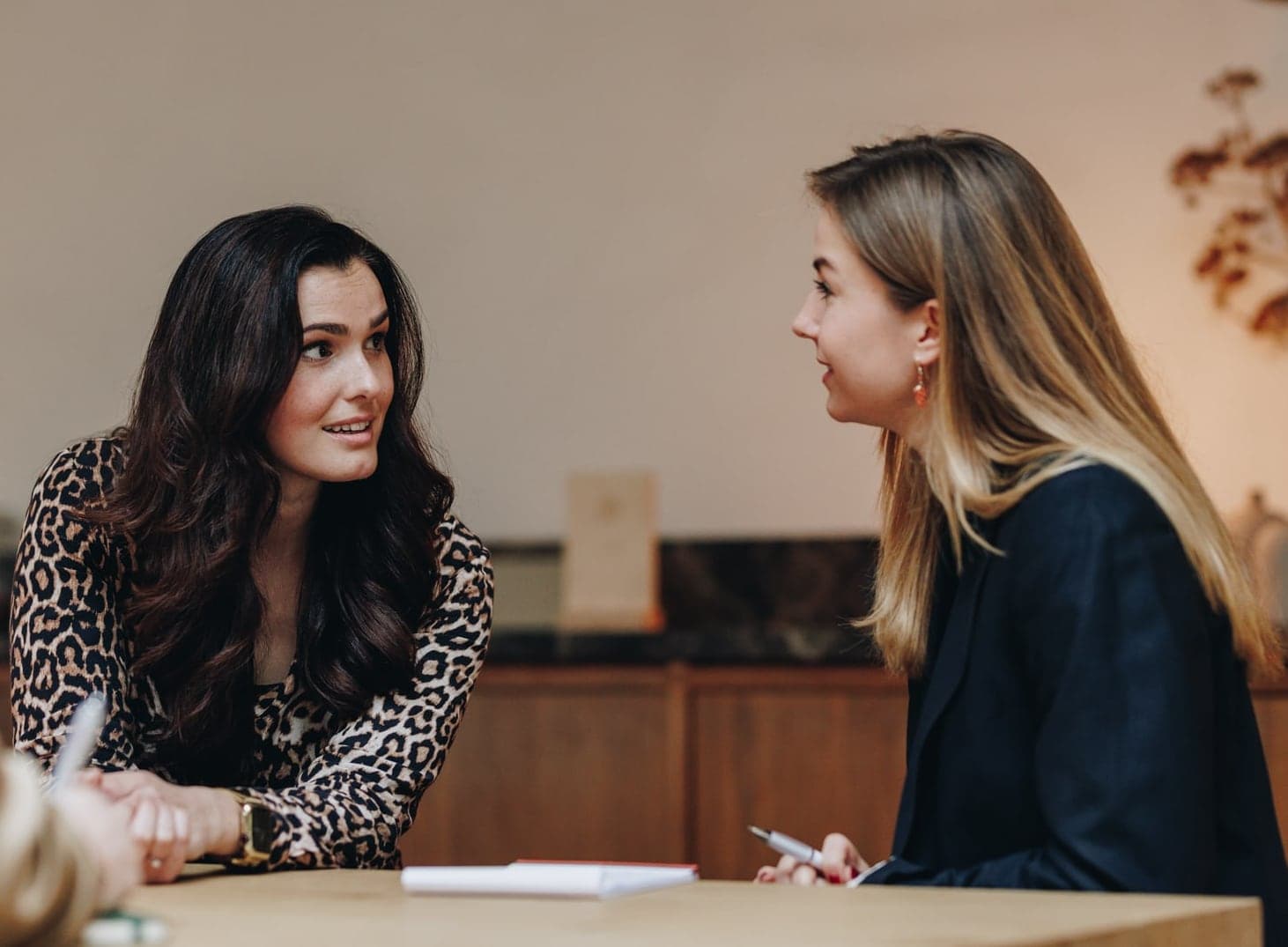 Presentatiecoach en deelnemer in gesprek aan tafel